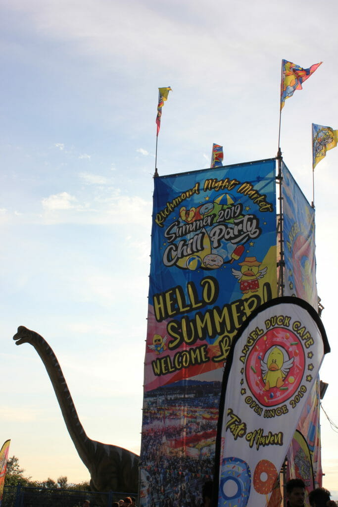 image of animatronic dinosaur and signs at entrance to Richmond Night Market