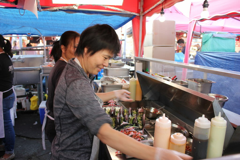 image of two women making sushi tacos at Nori Express food stall at Richmond Night Market