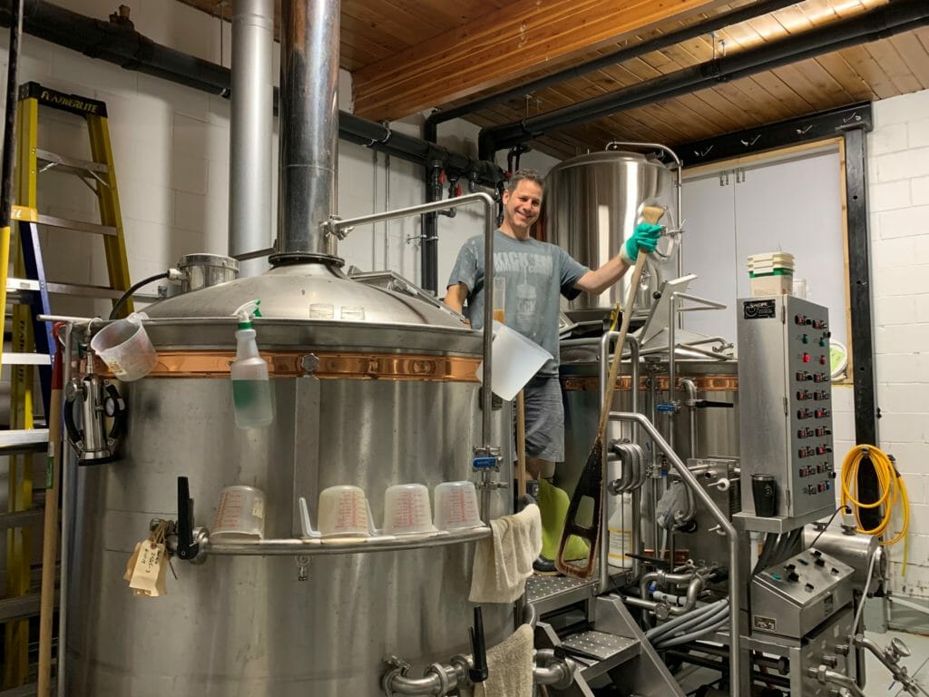 brewmaster at Backroads Brewing in Nelson, BC, next to the latest brew batch