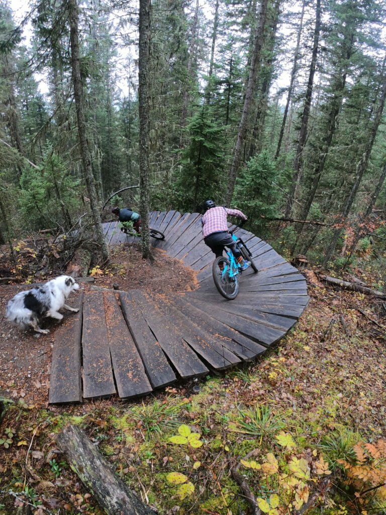 image of two mountain bikers and a dog on trails in Prince George, BC