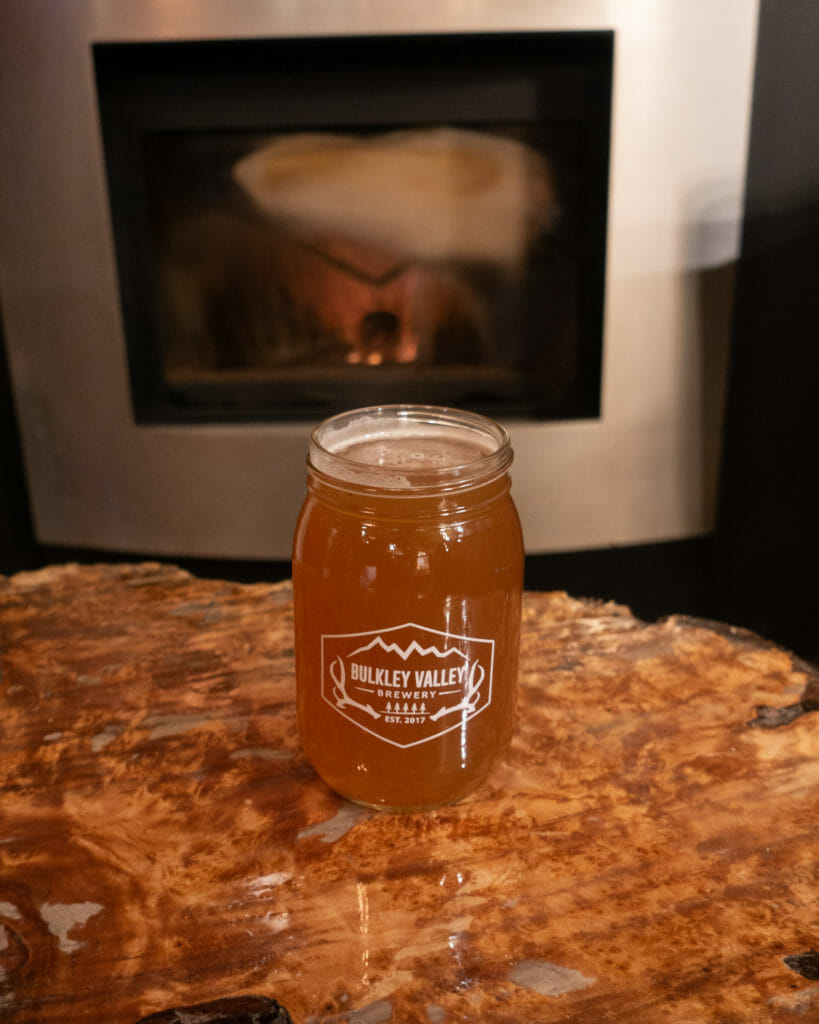 image of mason jar glass with beer from Bulkley Valley Brewery on wooden table