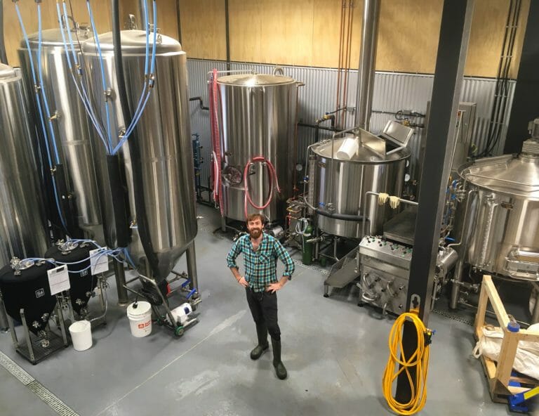 Smithers Brewing Company's co-owner and brewmaster, Cam McKeigan, standing among the tanks in the brewhouse.