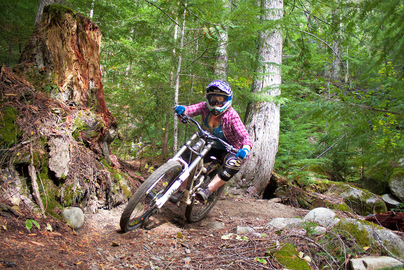 West Kootenay biking - Woman riding mountain bike trail in forest near Salmo