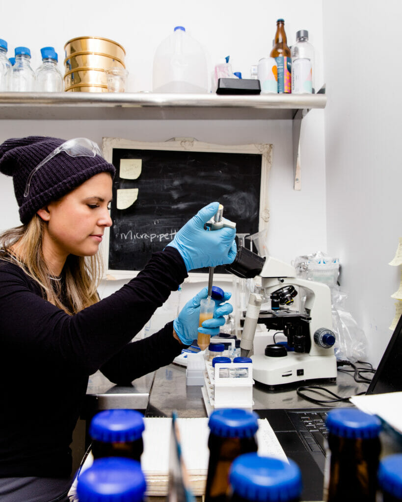 Ashley Brooks from Four Winds Brewing lab pipetting, photo credit Alison Page