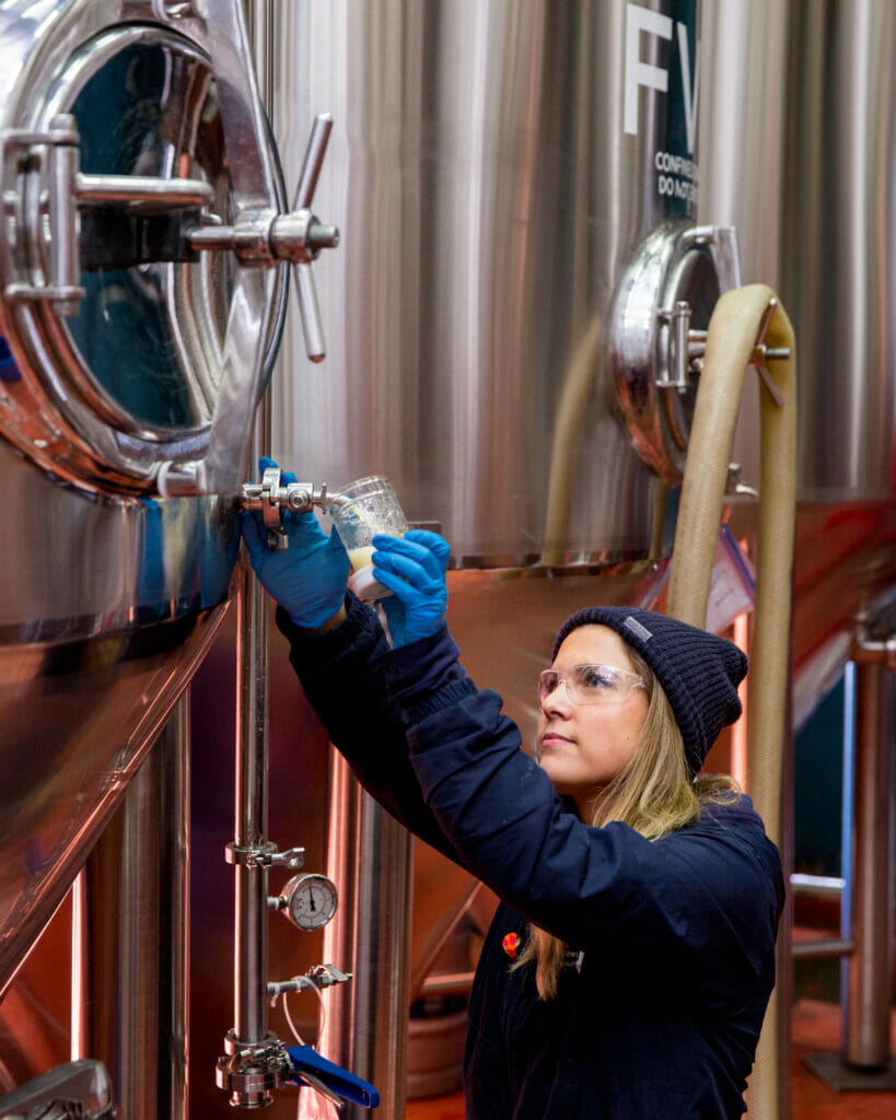 Ashley Brooks from Four Winds Brewing testing sample off tank, photo credit Alison Page