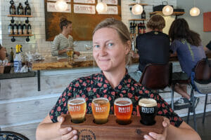 Author Bonnie Todd with a beer flight at Rusted Rake Brewing