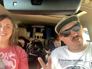 A selfie of Rob and family packed into their SUV and ready for a road trip