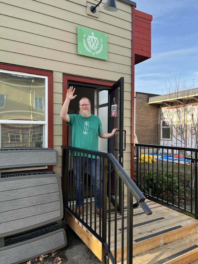 Michael Morgan waving from the front door of Mile Zero Brewing in Metchosin