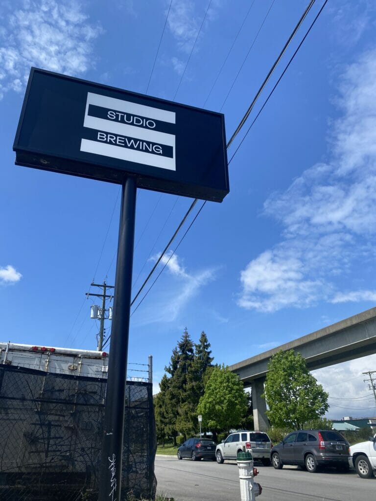 The Studio Brewing sign against a bright blue sky