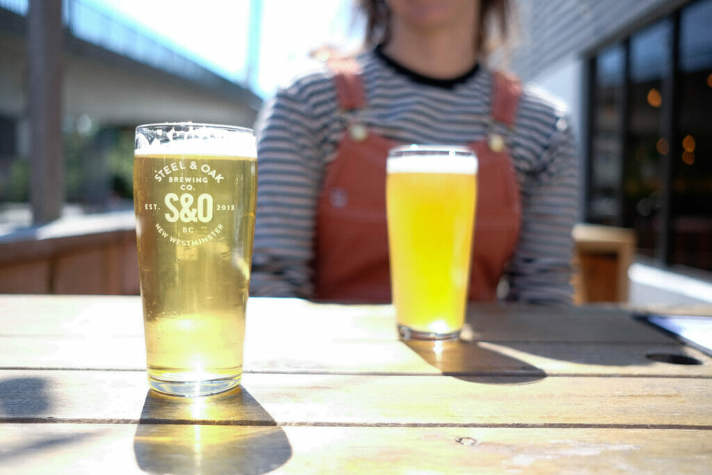 Light golden pints in the sunshine on the patio at Steel & Oak Brewing in New Westminster, BC