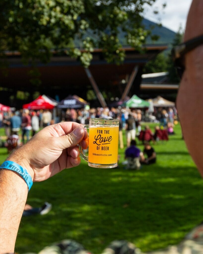 A sample glass with crowd in the background at Whistler Village Beer Festival