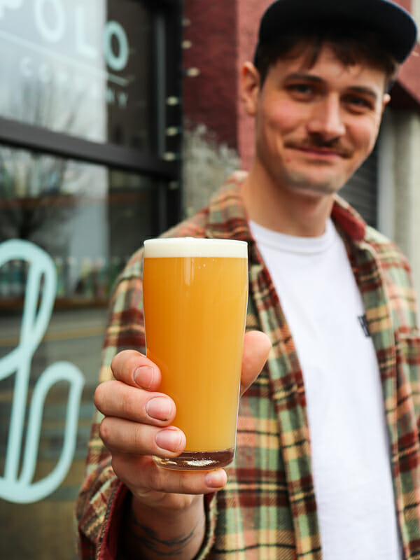 Connor Blanchard from Luppolo Brewing, with a glass of Party Animal Hazy IPA made with thiolized yeast and alternative hop products