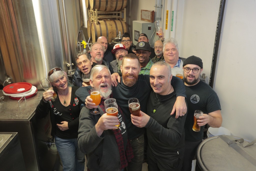 Tony Dewald smiles among a group of craft beer industry folks at Brassneck Brewing